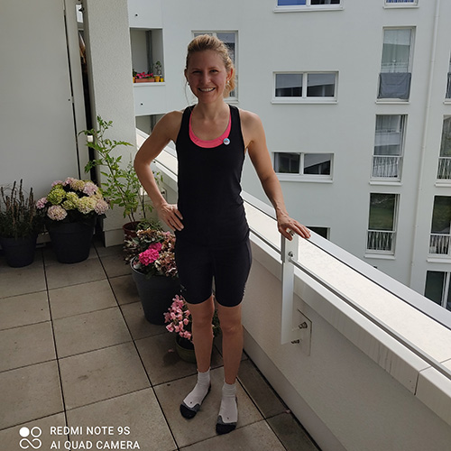Muko-Spendenlauf 2021 - Anna steht nach dem Lauf in Socken und Laufkleidung auf dem Balkon