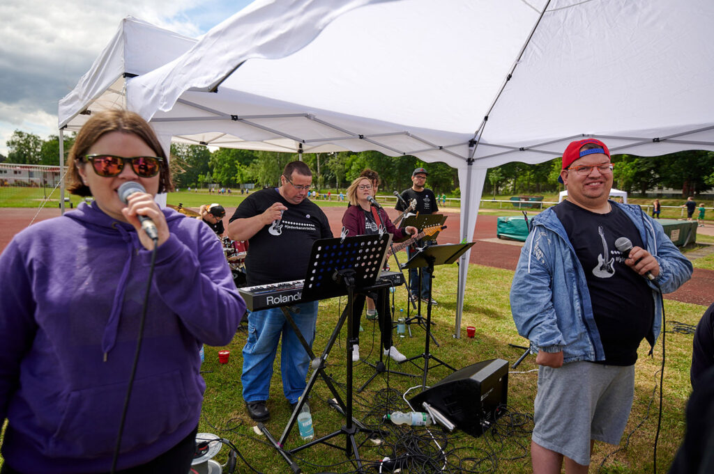 Foto vom 17. Muko-Spendenlauf 2024: Die Hand Hand in Hand, eine Person singt